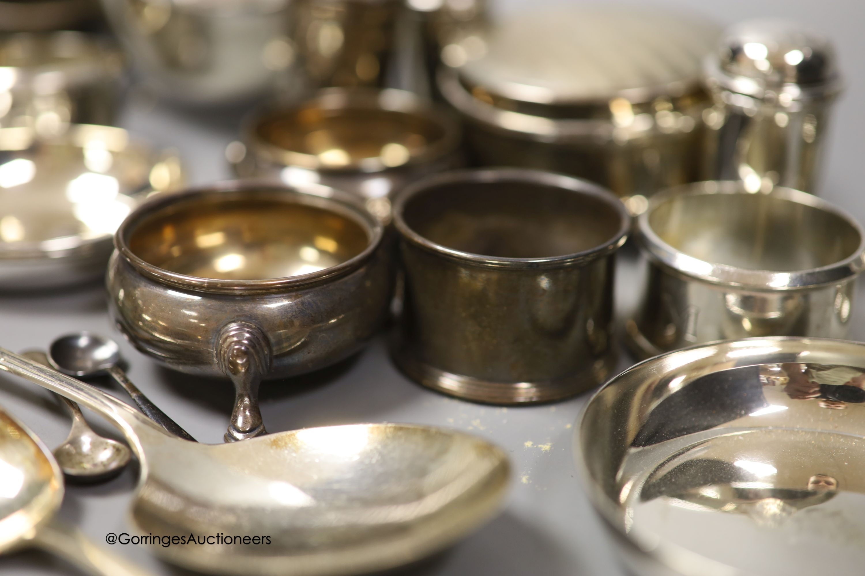 A group of minor silver including a George V trinket box, sauceboat, pair of soup spoons, pair of napkin rings, two bun salts, four small dishes, condiments etc. and three plated items.